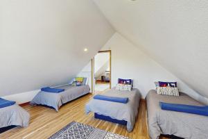 Habitación en el ático con 3 camas y espejo. en Cozy Coast Modern, en Nedonna Beach