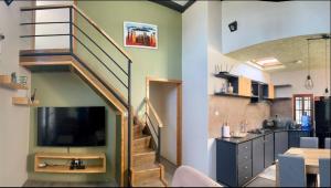 a living room with a staircase with a television at Abasimba House Arusha in Themi