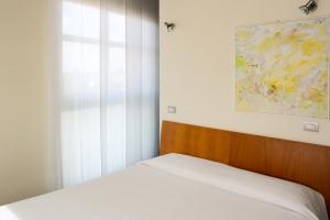 a bedroom with a bed and a window and a painting at Vista Hotel & Residence in Mantova