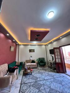 ein Wohnzimmer mit grünen Sofas und einer Decke in der Unterkunft Tabrany in Qaryat Abū Bakr aş Şiddīq