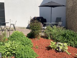 a patio with tables and chairs and an umbrella at Hôtel Normandie in Rimouski