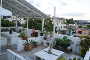 un patio avec des plantes en pot sur un mur blanc dans l'établissement 302 Don Juan Local & Cómodo, à San Felipe de Puerto Plata