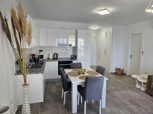 eine Küche und ein Esszimmer mit Tisch und Stühlen in der Unterkunft Cozy apartment at Thalassa Beach Resort, Northern Cyprus in Paralimni