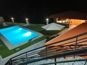 a swimming pool at night with an umbrella at Eucalyptus Pink House in Covelo