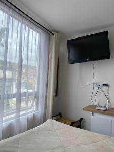 a bedroom with a bed and a window with a television at Apartamento floral in Tunja