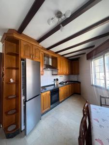 a kitchen with wooden cabinets and a stainless steel refrigerator at Piso Super Espacioso en Cambados Centro in Cambados