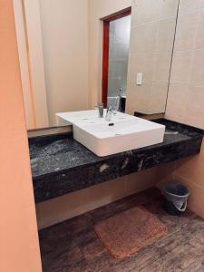 a bathroom with a white sink and a mirror at Alojamientos Premiun Centro in Termas de Río Hondo +10 photos
