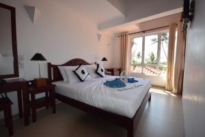 Llit o llits en una habitació de Amal Beach Hotel