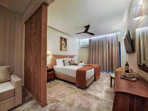 a hotel room with a bed and a chair and a couch at MarieChristine Suites in Mesongi