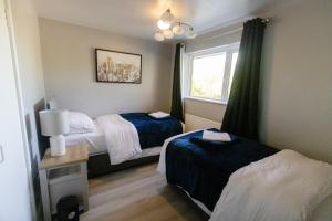 a hotel room with two beds and a window at 4 Bedroom Gateway in Winchester in Winchester