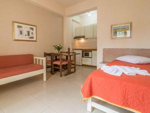 a bedroom with a bed and a table and a kitchen at Lito Apartments Paleochora in Palaiochora