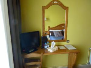 a desk with a mirror and a computer on it at Petit Hotel in Pas de la Casa