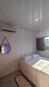 a small bedroom with a bed and a window at Recanto Ebenézer in Taipu