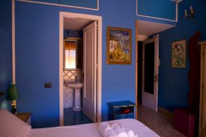 Dormitorio azul con cama y lavamanos en Sultan Suites, en Palermo