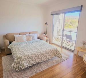 a bedroom with a bed and a view of a balcony at Modern Townhouse in Wright in Weston Creek