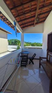 a porch with a table and chairs and a view of the ocean at Recanto Ebenézer in Taipu