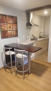 a kitchen with a table and two bar stools at Apartamento Estocolmo I in Valdivia