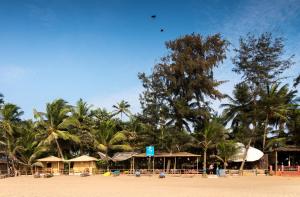 a resort on the beach with palm trees in the background at Jardim a Mar in Agonda
