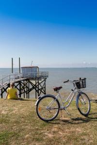 een fiets geparkeerd op het gras naast een pier bij Thalazur Royan - Hôtel & Spa in Royan