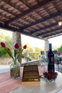 a bottle of wine and a vase with flowers on a table at Apartments by the sea Loviste, Peljesac - 24163 in Lovište