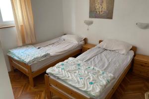 two twin beds in a room with at Apartments by the sea Kukljica, Ugljan - 24177 in Kukljica