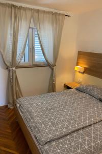 a bedroom with a bed and a window at Apartments by the sea Kukljica, Ugljan - 24177 in Kukljica