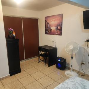 a room with a bed and a desk with a fan at Cozy & comfortable crib in Carolina +6 photos