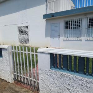 a white house with a fence and a door at Cozy & comfortable crib in Carolina