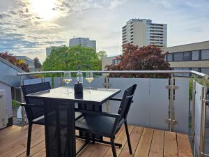 a balcony with a table and two glasses of wine at Design-Apartments I Klimaanlage I Boxspring I Nespresso I Parklplatz in Weil am Rhein