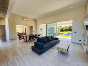 un salon avec un canapé bleu et une table dans l'établissement Costa Esmeralda 4 Dorm,4 Baños,10 perso, pileta, à Costa Esmeralda