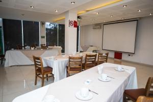 a conference room with tables and a white screen at Hotel Grand Elizabeth in Durango