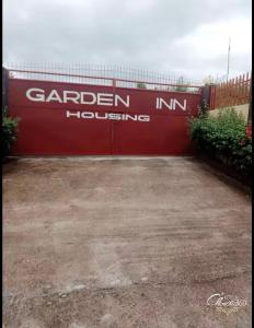 a red garage door with the words garden innhousing at Garden INN in Liloan +4 photos