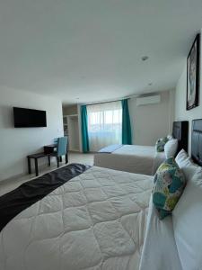 a hotel room with two beds and a flat screen tv at ABERDEEN HOTEL DOLORES HIDALGO in Dolores Hidalgo