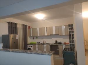 a kitchen with a counter top and a refrigerator at Kaza Horta in Tarrafal