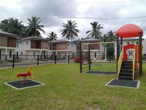a playground with a slide and a swing set at Cozy Holiday Home in San Pablo City for Groups of 8-10 in Tiaong