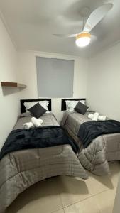 two beds in a bedroom with a ceiling at Seminate Apartamento in Franca