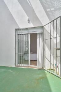 an empty room with a balcony with green flooring at Hasta para 6 viajeros, Luz Natural Cocina Equipada in Algeciras