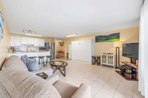 a living room with a couch and a kitchen at Amazing Beachfront Condo by Pool in Hauula