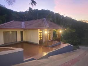 a small house with a porch with lights on it at River Valley Retreat Coorg in Madikeri