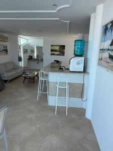 a kitchen and living room with a counter and stools at Luxury Mansion in Porto das Dunas in Aquiraz +29 photos
