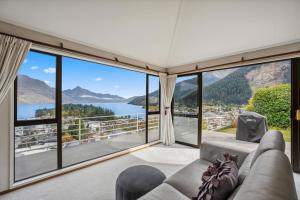 a living room with a view of the water and mountains at The view of Queenstown in Queenstown