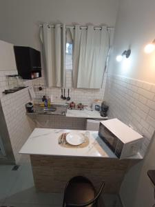 a kitchen with a counter with a microwave on it at Studio Home in Jacareí +8 photos