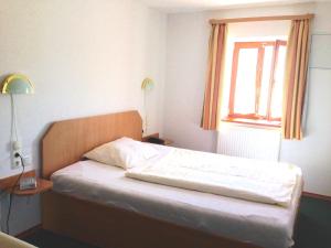 Bett in einem Zimmer mit einem Fenster und einem Bett sidx sidx sidx sidx in der Unterkunft Pension Poschmühle in Traunreut