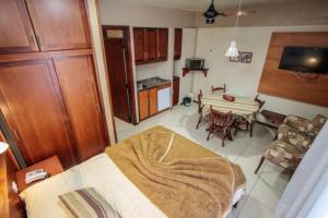 a kitchen and a living room with a table at Pousada do Serrano - Rua Torta in Gramado