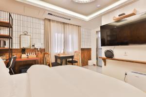 a bedroom with a bed and a desk and a television at Riverside in February Gyeongbuk Gyeongsan in Gyeongsan