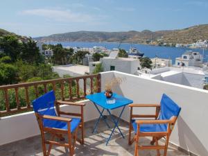 a table and chairs on a balcony with a view of the water at Pension Sofia Amorgos-Katapola in Katapola