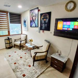 ein Wohnzimmer mit zwei Sesseln und einem Flachbildfernseher in der Unterkunft Luxury Monastery Apart & Hotel in Trabzon + 22 Fotos