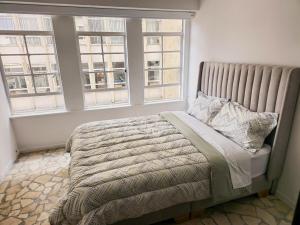 1 cama en un dormitorio con 2 ventanas en Apartment in La Candelaria, en Bogotá