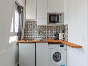 a kitchen with a washing machine and a microwave at Cosy studio 2P Montmartre - View of Sacré Coeur in Paris