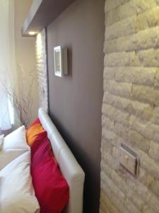 Habitación con cama y pared de ladrillo en Don Mico 'Case Vacanze', en Riposto